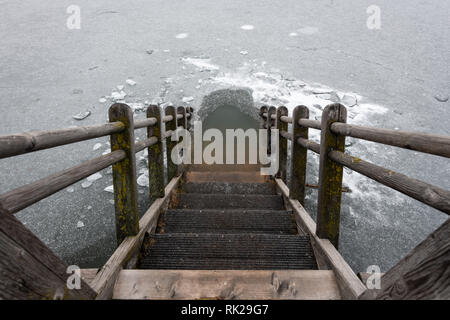 Scale di legno che conduce in un lago ghiacciato (Alte Donau, Vienna Austria) Foto Stock