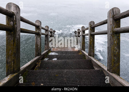 Scale di legno che conduce in un lago ghiacciato (Alte Donau, Vienna Austria) Foto Stock