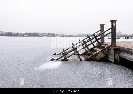 Scale di legno che conduce in un lago ghiacciato (Alte Donau, Vienna Austria) Foto Stock