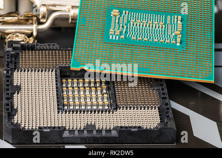 Installazione del processore nel socket sulla scheda madre del computer. Close-up di unità centrale di elaborazione. Sostituzione di componenti hardware. Dettaglio del microchip. Foto Stock