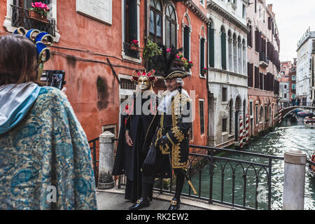 Venezia, Italia - 09 febbraio 2018: coppia di maschere di carnevale in posa per i fotografi su un ponte Foto Stock