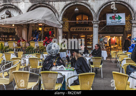 Venezia, Italia - 09 febbraio 2018: coppia di maschere di carnevale con prima colazione in piazza San Marco Foto Stock