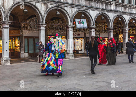 Venezia, Italia - 09 febbraio 2018: colorato maschere veneziane a piedi in Piazza San Marco Foto Stock