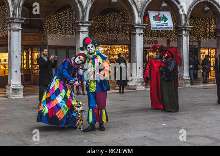 Venezia, Italia - 09 febbraio 2018: colorato maschere veneziane a piedi in Piazza San Marco Foto Stock