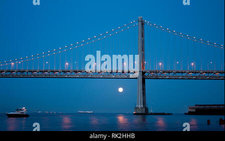 Il Bay Bridge a guardare oltre una grande luna piena Foto Stock