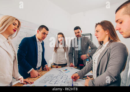 Gruppo di progettisti ambiziosi stanno guardando il disegno Foto Stock