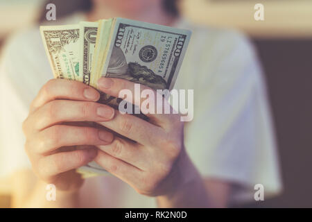 Donna informale è il conteggio dollaro americano banconote, close up delle mani con il denaro Foto Stock