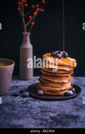 Pila di pancake con sciroppo d'acero pioggerella e mirtilli Foto Stock