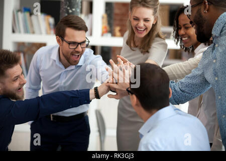 Emozionato motivati multi-etnico persone del team dare alta cinque in ufficio Foto Stock