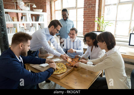 Felice personale diverse persone che condividono la pizza a rottura in office Foto Stock