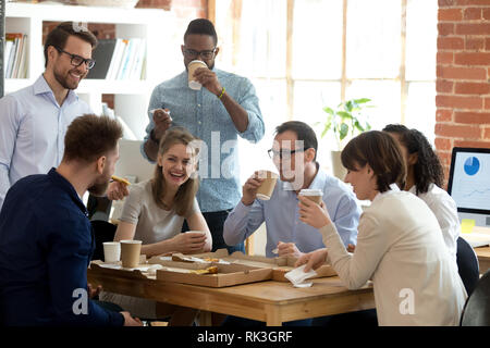 Multi-etnico gruppo dipendenti godono di cibo da asporto conversazione amichevole in office Foto Stock