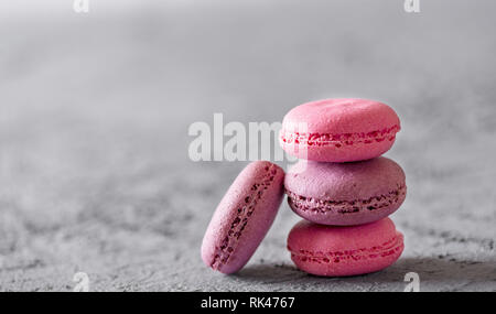 Bella colorata deliziosi dessert makarons, stack sulla pietra grigia sullo sfondo. Foto Stock