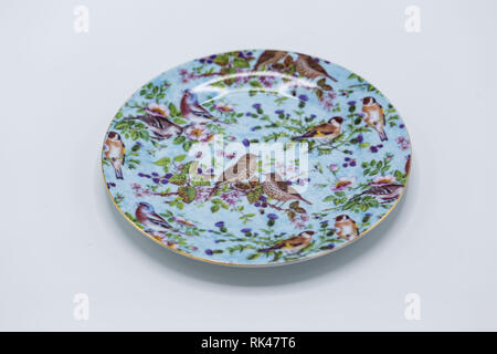 Una piccola luce blu piatto decorativo con fiori e uccelli su di esso Foto Stock