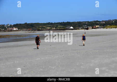 Un paio di escursionisti a piedi nella baia di Vazon sull'Isola di Guernsey sentiero costiero, Isole del Canale.UK. Foto Stock