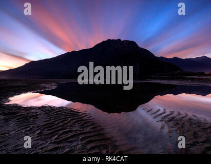 Tramonto nuvole mirroring in acqua, Novate Mezzola, Val Chiavenna, provincia di Sondrio e della Valtellina, Lombardia, Italia Foto Stock