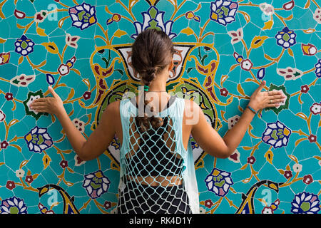 Donna Travaler su East Asia moschea sullo sfondo dell'archivio. Femmina caucasica in piedi in ceramica islamica ornamento cupola del Tempio. Arco di mosaico storico e distintivo. Foto Stock