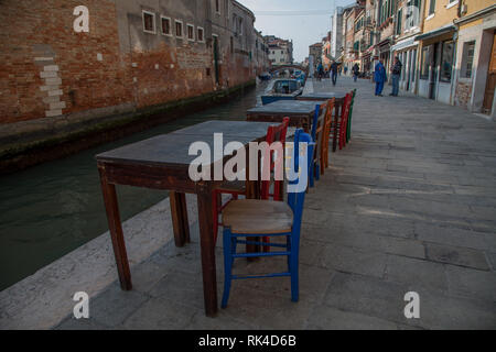 Tavoli e sedie nelle strade della città vecchia di Venezia Foto Stock