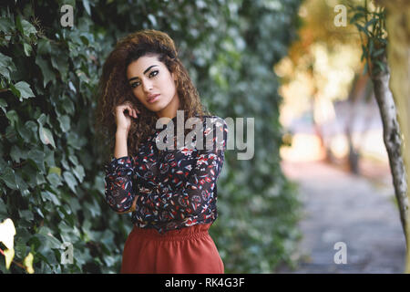 Bellissima giovane donna araba con nero capelli ricci. Foto Stock