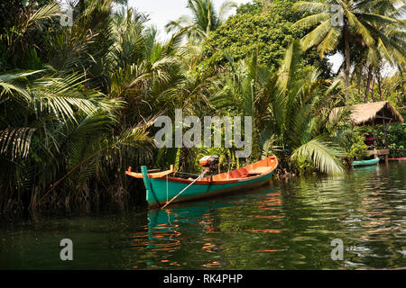 Cambogia, Koh Kong Provincia, Tatai, verde e arancione barca dipinta ormeggiato sul fiume Tatai Foto Stock
