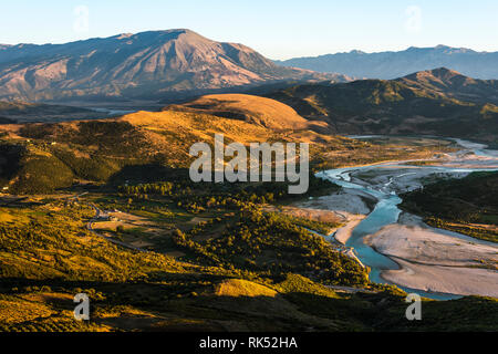 Paesaggio albanese nel villaggio di Byllis a nord-est di Vlore al tramonto - Vista del paesaggio idilliaco con pietre, river band e montagne, Byllis, Albania Foto Stock