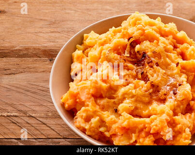 Miscela di purè di carote cotte e patate servita in una ciotola come un piatto di lato per un pasto in un ritagliato closeup view Foto Stock