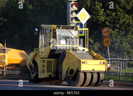 Giallo asfalto asfalto rullo e lastricatore le riparazioni della macchina su strada Foto Stock