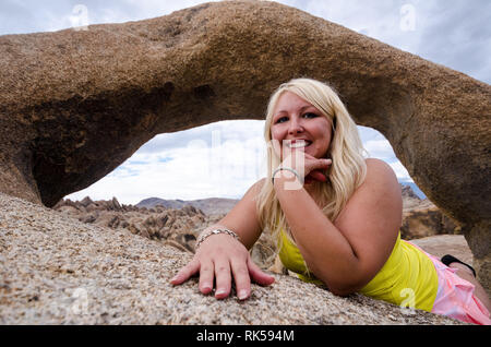 Donna bionda pone all'interno di Moibus Arch, noto anche come il portale di Whitney Arch, in Alabama area collinare della California Foto Stock