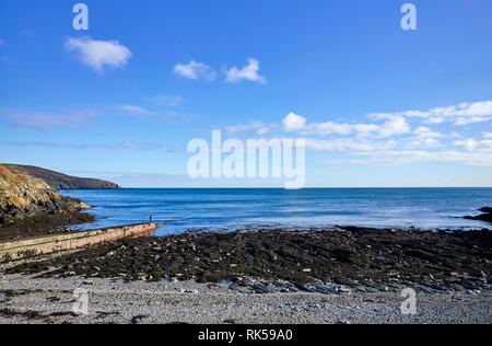 Donna in piedi sull'estremità di un molo al porto Soderick nell'Isola di Man Foto Stock