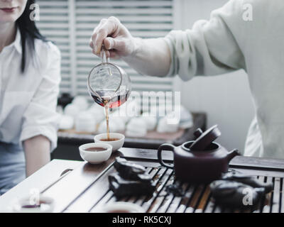Cerimonia del tè cinese. Master versando puer tea in tazze. Pu Erh della cerimonia del tè. Foto Stock
