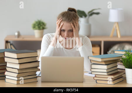 Sottolineato studente di college stanchi di difficile apprendimento con libri computer portatile Foto Stock