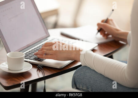 Donna studente rendendo note studiando l'apprendimento online con il computer Foto Stock