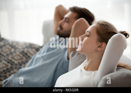 Felice calma giovane godendo relax avente nap sul divano la respirazione Foto Stock