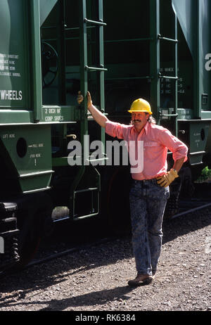 Ferrovia lavoratore in piedi accanto ad un treno auto, Montana, USA Foto Stock