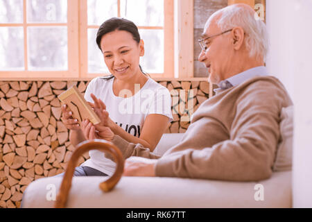 Lieto uomo maturo seduto in posizione semi Foto Stock
