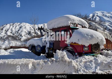 La questione del Kashmir, India. 9 Feb 2019. Un recupero a filamento- carrello visto coperte di neve su una chiusa Autostrada nazionale in Qazigund, a circa 85km da Srinagar, Indiano Kashmir amministrato. La principale strada Nazionale che collega la valle con il resto del paese sono rimaste chiuse il sabato per il quarto giorno consecutivo dopo una valanga di uccidere sette persone inclusi i tre poliziotti, i due vigili del fuoco e dei due prigionieri. Credito: SOPA Immagini limitata/Alamy Live News Foto Stock