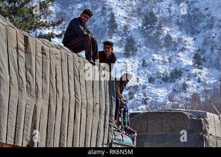 La questione del Kashmir, India. 9 Feb 2019. Driver intrecciati sono visto seduto sulla parte superiore di un carrello portante di alimentazione essenziali su una chiusa Autostrada nazionale in Qazigund, a circa 85km da Srinagar, Indiano Kashmir amministrato. La principale strada Nazionale che collega la valle con il resto del paese sono rimaste chiuse il sabato per il quarto giorno consecutivo dopo una valanga di uccidere sette persone inclusi i tre poliziotti, i due vigili del fuoco e dei due prigionieri. Credito: SOPA Immagini limitata/Alamy Live News Foto Stock