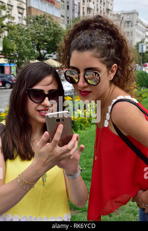 Due giovani attraenti donne adulte in vacanza guardando foto scattata in località turistica, la Piazza di Venceslao, Praga Foto Stock