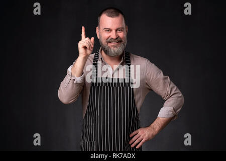Cook fornisce consulenza e raccomandazione, puntando il suo dito indice verso l'alto Foto Stock