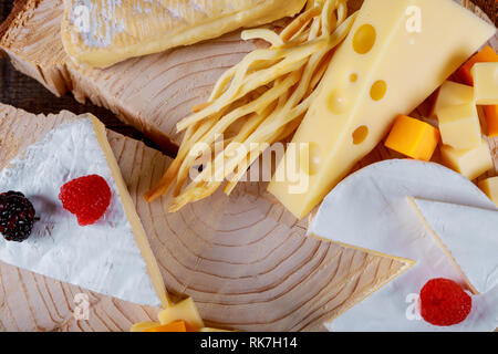 Vari tipi di formaggio su un tavolo di legno. Foto Stock