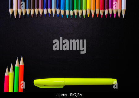 Scuola di disegno e fornisce su sfondo nero. Matite colorate, matite evidenziatore e. Con copia spazio. Foto Stock