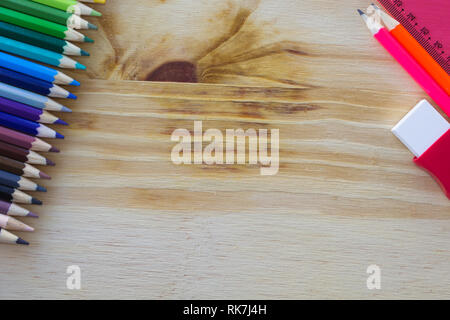 Scuola di disegno e fornisce su un tavolo di legno. Matite colorate, gomma matita e righello. Con copia spazio. Foto Stock