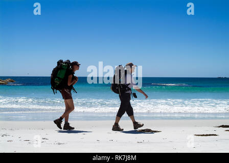 Gli ospiti della culla rifugi di montagna a piedi lungo una spiaggia remota sulla baia di incendi a piedi, quattro giorni di escursione che attraversa la Tasmania è molto più a nord-est della costa. Foto Stock