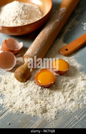 Farina di grano tenero e uova sul tavolo di legno - verticale - primo piano Foto Stock