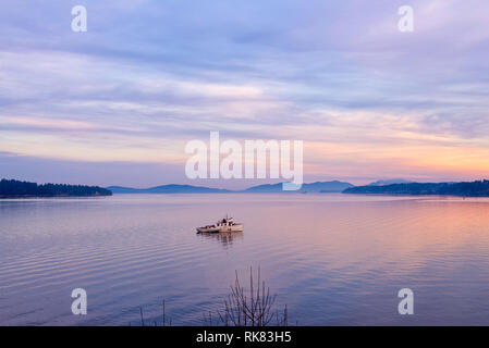 Vista del tramonto al mare con una piccola imbarcazione prese a Ladysmith in Isola di Vancouver, Canada Foto Stock