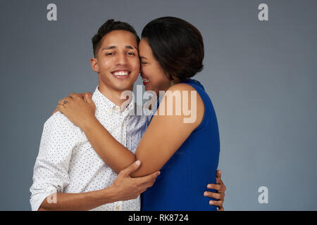 Carino felice coppia giovane isolato su grigio di sfondo per studio Foto Stock
