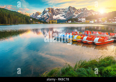 Tramonti mozzafiato e alpina famosa Lago di Misurina. Alta Sorapis gruppo montuoso in background e spettacolare Lago di Misurina con barche colorate a su Foto Stock