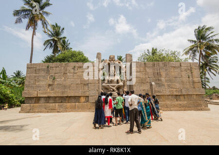 I devoti e visitatori affollano per vedere gli imponenti Lakshmi Narasimha Tempio statua in Hampi, Karnataka, India Foto Stock