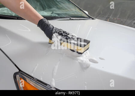 Auto nel processo di lavaggio auto manuale con una spugna gialla e schiuma  Foto stock - Alamy