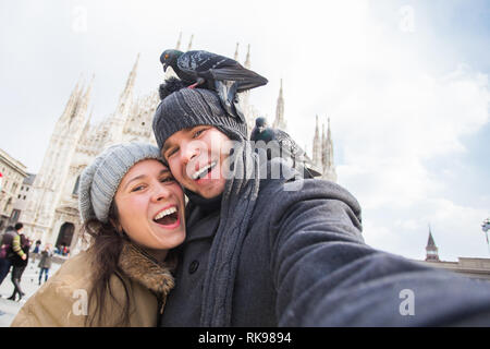 Viaggi, Italia e divertente giovane concetto - Happy turisti prendendo un autoritratto con piccioni nella parte anteriore del Duomo di Milano Foto Stock