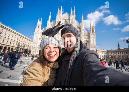 Viaggi, Italia e divertente giovane concetto - Happy turisti prendendo un autoritratto con piccioni nella parte anteriore del Duomo di Milano Foto Stock